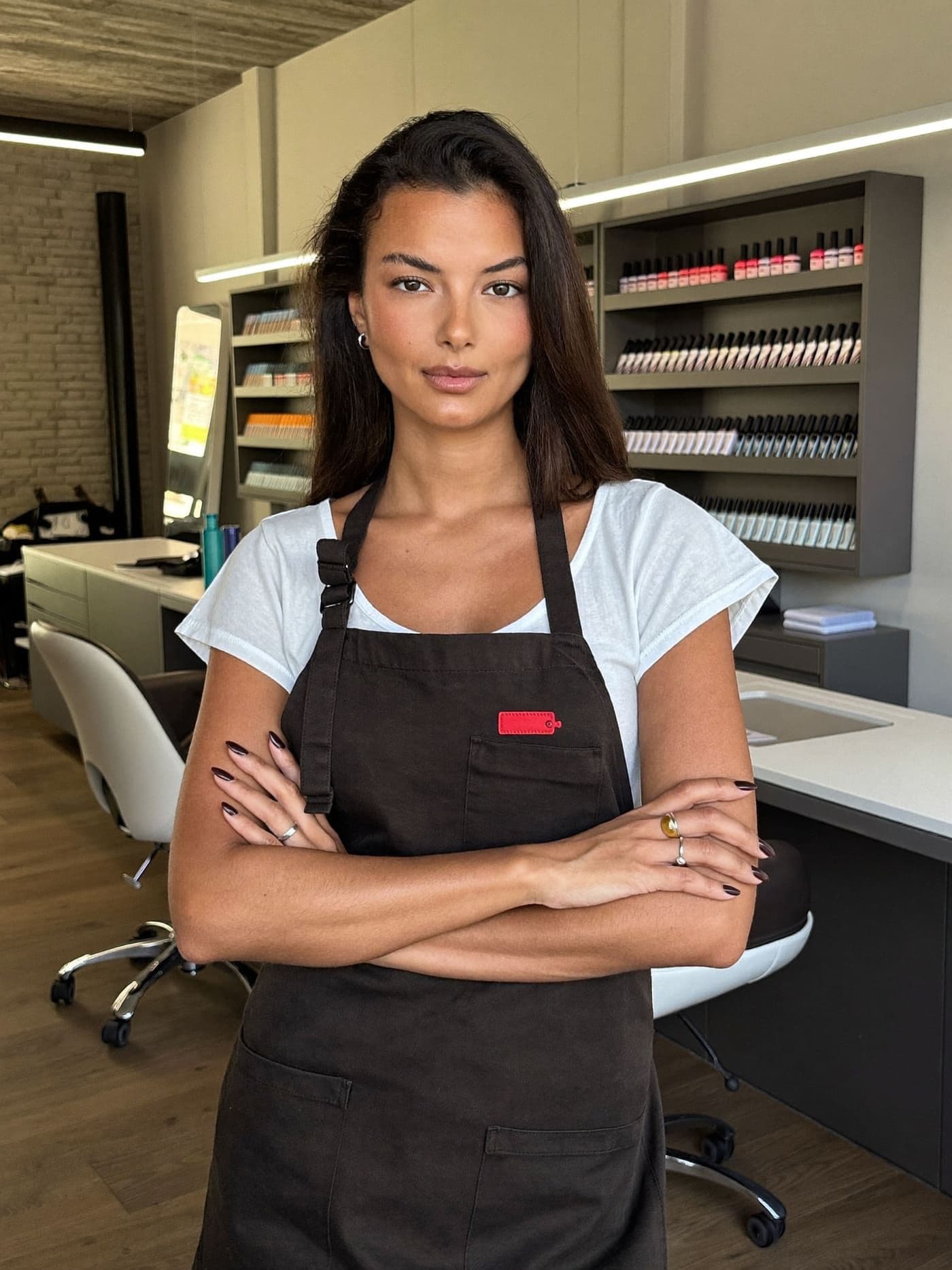 A confident nail salon owner standing in her salon